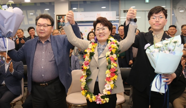 권향엽 당선인이 남편, 아들과 함께 지지자들에게 인사하고 있다.