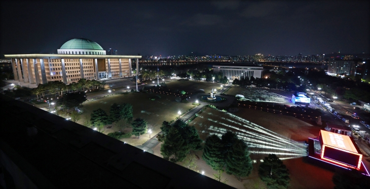 제22대 국회의원 선거일인 10일 밤 서울 여의도 국회의사당 앞에 각 방송사가 개표 방송을 위해 마련한 중계소가 조명을 내뿜고 있다.    연합뉴스