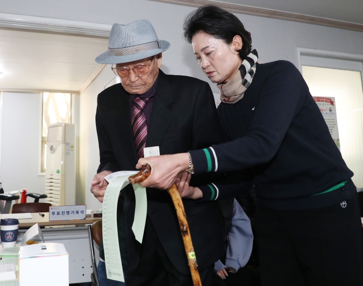 부산 부산진구 개금3동 제8투표소에서 108세 유권자인 이순동(왼쪽) 어르신이 투표용지를 받고 있다. 부산 뉴스1