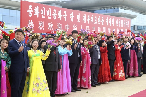 평양 시민들이 11일 순안공항에서 북중 친선의 해 개막식 참석을 위해 방북한 중국 대표단을 환영하고 있다. 평양 AP 연합뉴스