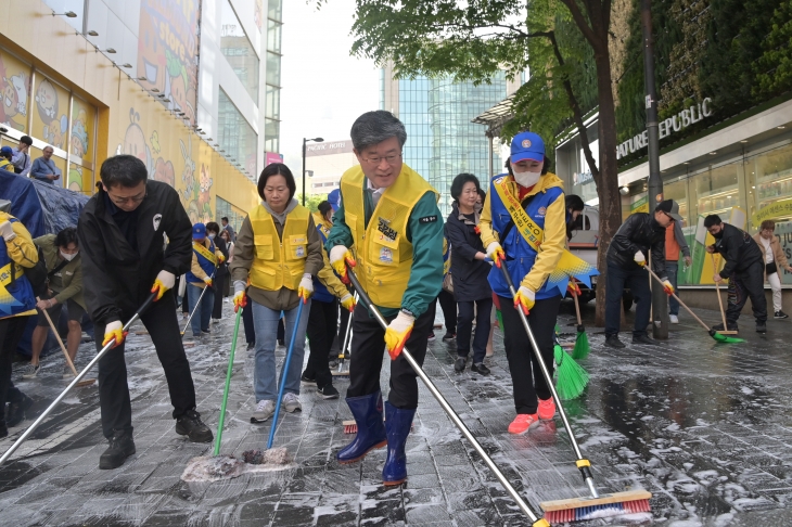 김길성 중구청장이 지난 18일 주민과 함께 명동길을 청소하고 있다.   중구 제공