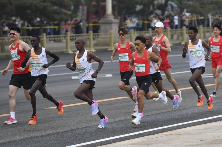 지난 14일 베이징에서 열린 베이징 하프마라톤 대회에서 중국의 허제가 아프리카 선수들과 나란히 달리고 있다. 2024.04.19 베이징 AP 뉴시스
