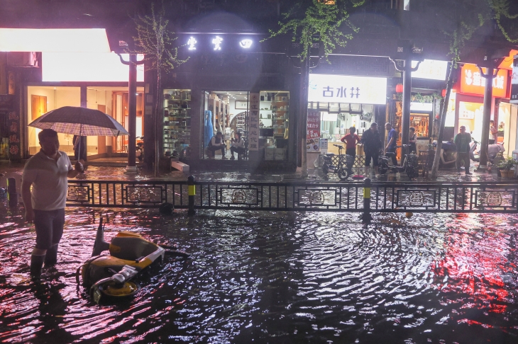 2일 중국 장시성 난창에 퐁풍으로 비와 우박이 쏟아지면서 사람들이 침수된 거리에 서 있다. 2024.4.2 난창 로이터 연합뉴스