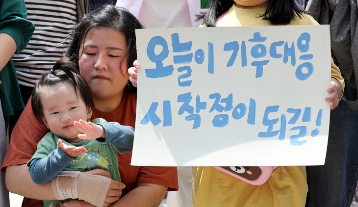 23일 서울 종로구 헌법재판소 앞에서 열린 ‘기후 헌법소원’ 첫 공개 변론 공동 기자회견에서 한 참석자가 ‘오늘이 기후대응 시작점이 되길’이라는 문구가 쓰인 손팻말을 들고 있다. 뉴스1