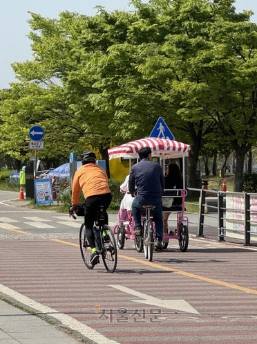 23일 자전거 도로에서 일반 자전거 운전자가 4인승 자전거를 피해 반대 차선으로 추월하는 모습.