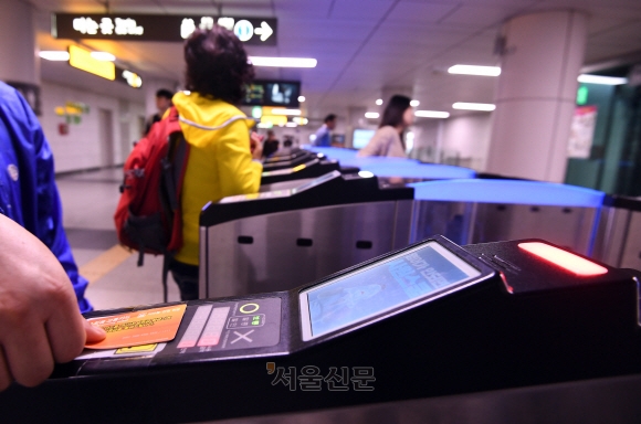 서울 중구 시청역에서 한 시민이 지하철을 타기 위해 교통카드를 개찰구에 찍고 들어서는 모습. 서울신문DB