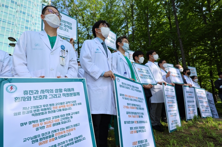 지난 3일 오전 송파구 서울아산병원에서 서울아산병원을 수련병원으로 둔 울산의대 교수들이 의대 증원 정책 철회를 요구하며 손팻말을 들고 있다. 연합뉴스