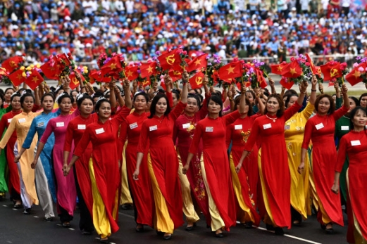 Women wave flags during official celebrations of the 70th anniversary of the 1954 Dien Bien Phu victory over French colonial forces at a stadium in Dien Bien Phu city on May 7, 2024. War veterans, soldiers and dignitaries gathered in Vietnam‘s Dien Bien Phu on May 7 to mark the 70th anniversary of the battle that ultimately brought an end to the French empire in Indochina. AFP 연합뉴스