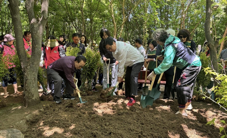 박일하 동작구청장(오른쪽 두번째)이 지난 16일 서달산 등산로 내에서 열린 ‘맨발의 동작’ 프로젝트 행사에서 주민들과 흙길 일대를 정비하고 있다. 동작구 제공
