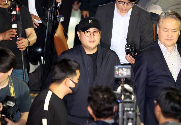 ‘음주 뺑소니’ 혐의를 받는 가수 김호중씨가 21일 안경과 모자를 쓴 모습으로 경찰 조사를 마친 지 약 6시간 만에 서울 강남경찰서에서 나와 이동하고 있다. 연합뉴스