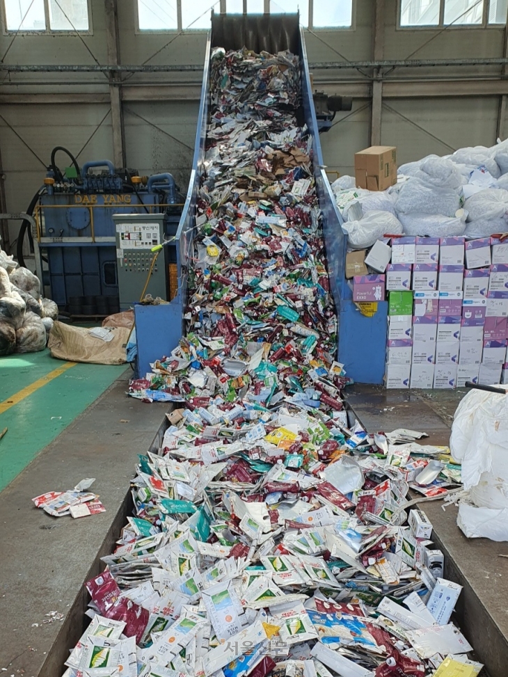 일차적으로 플라스틱이나 캔, 이물질 등과 구분해 선별한 종이팩 쓰레기는 컨베이어 벨트 위에서 한번 더 분류된다.  부산 김예슬 기자
