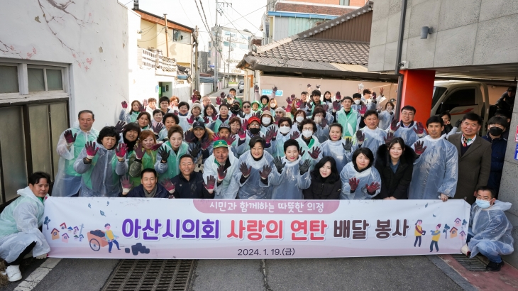 충남 아산시의원들이 주민들과 사랑의 연탄 배달 후 기념촬영을 하고 있다. 아산시의회 제공