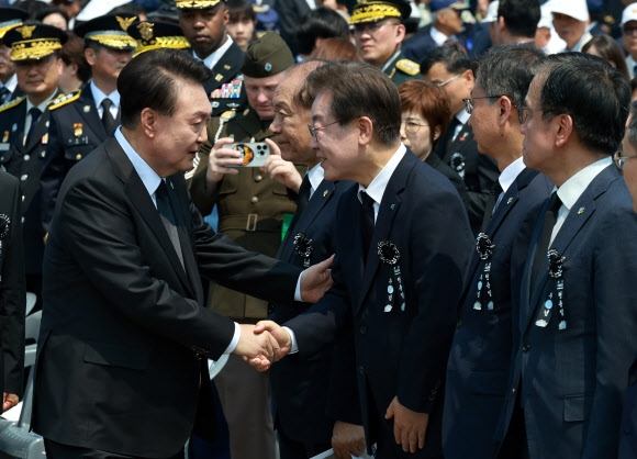 윤석열 대통령이 6일 서울 동작구 국립서울현충원에서 열린 제69회 현충일 추념식이 끝난 뒤 퇴장하며 더불어민주당 이재명 대표와 인사하고 있다.  연합뉴스