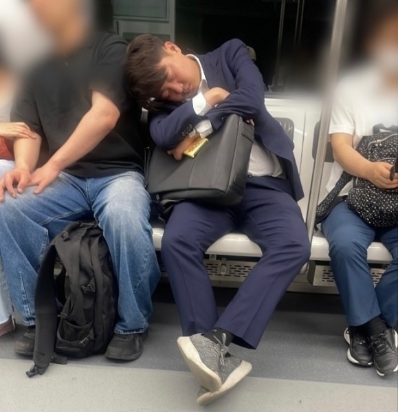 이준석 개혁신당 의원이 퇴근길 지하철 4호선에서 한 승객의 어깨에 기댄 채 자고 있다. 뉴스1