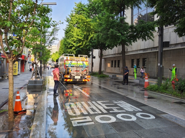 서울 종로구 관계자들이 지난 19일 세종대로 일대에서 물청소하고 있다.   종로구 제공