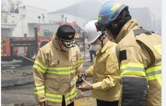 김동연 경기도지사는 24일 ‘화성 전곡해양산단 일차전지 공장 화재’ 현장에서 소방 관계자들과 함께 자신의 신발에 박힌 못을 바라고 있다. (김동연 경기지사 SNS 캡처)