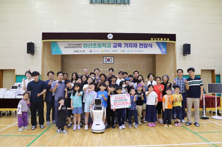 마산초등학교 교육 기자재 전달식에 참여한 행사 관계자 및 마산초 학생 등이 기념촬영을 하고 있다. 이마트 제공