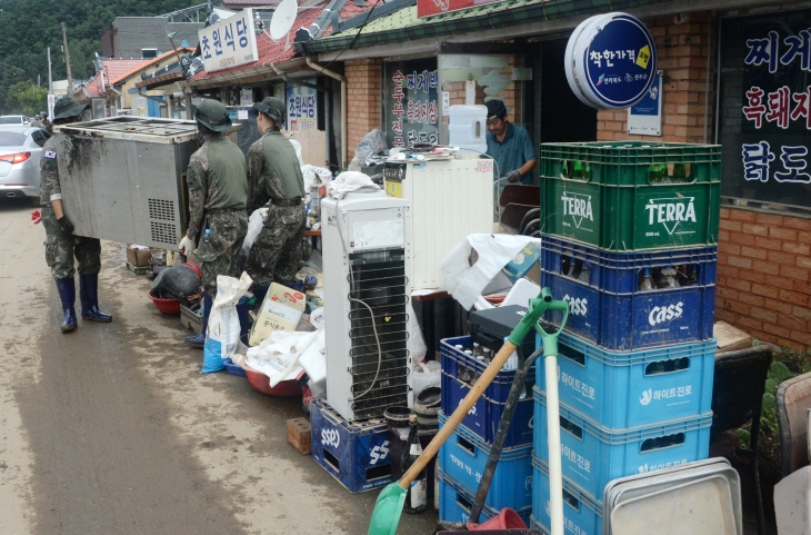 11일 집중호우로 피해를 입은 전북 완주군 운주면에서 군장병들이 시민들의 피해 복구를 위해 무거운 물품을 옮기고 있다. 밤사이 쏟아진 폭우로 하천이 범람해 주민들이 고립됐다 구조되는 등 피해가 잇따랐다. 완주 뉴시스