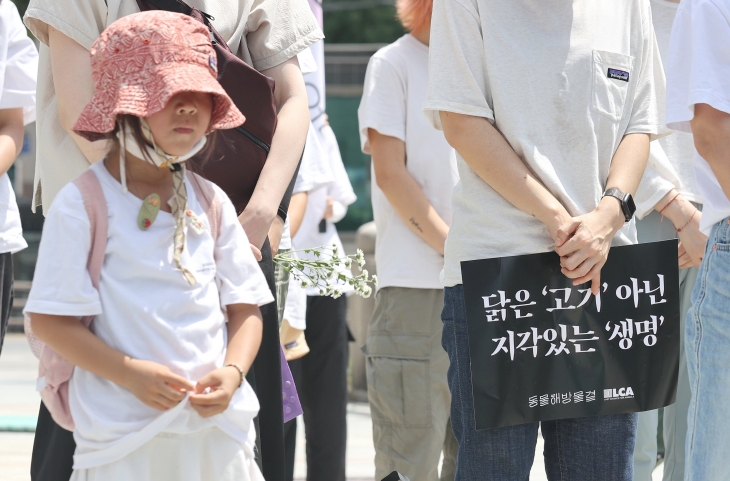 초복인 15일 오전 서울 종로구 보신각 앞에서 열린 ‘2024 복날추모행동’에서 참석자들이 도살된 닭을 애도하며 묵념하고 있다. 2024.7.15 연합뉴스