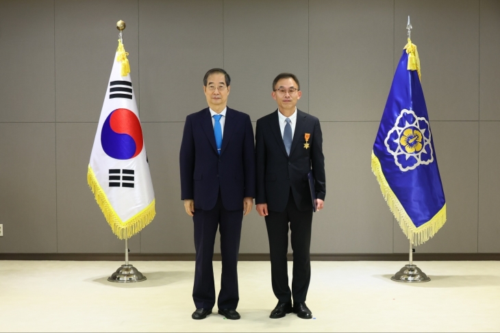 한덕수 국무총리가 노원구청 소속 강문영 주무관에게 적극행정 유공 포상 훈장을 수상하고 기념사진을 찍고 있다.   노원구 제공