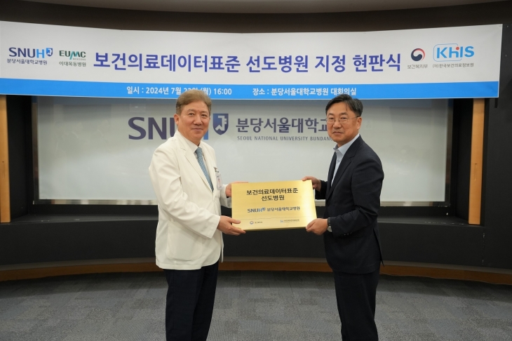 송정한(왼쪽) 분당서울대병원 원장이 22일 분당서울대병원 대회의실에서 고형우 보건복지부 첨단의료지원관으로부터 보건의료데이터 표준 선도병원 현판을 전달 받고 있다.   분당서울대병원 제공