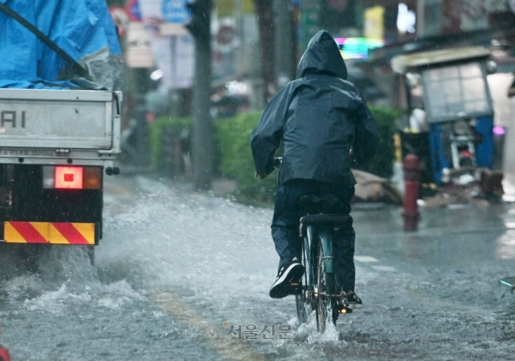 중부지역에 호우경보가 내린 지난 17일 오전 서울 종로를 지나는 한 시민이 빗속에 자전거를 타고 있다. 도준석 전문기자