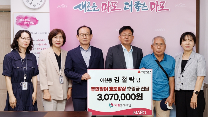 고이 모은 307만원을 효도밥상에 기부한 김철락(오른쪽 두번째)씨가 지난 18일 후원금 기탁식에서 박강수(오른쪽 세번째) 마포구청장과 기념촬영을 하고 있다. 마포구 제공