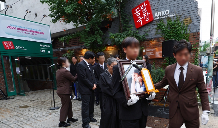 김민기의 발인식이 엄수된 24일 오전 유족들이 서울 대학로의 옛 학전 소극장에 들른 뒤 운구 차량으로 향하고 있다. 뉴시스