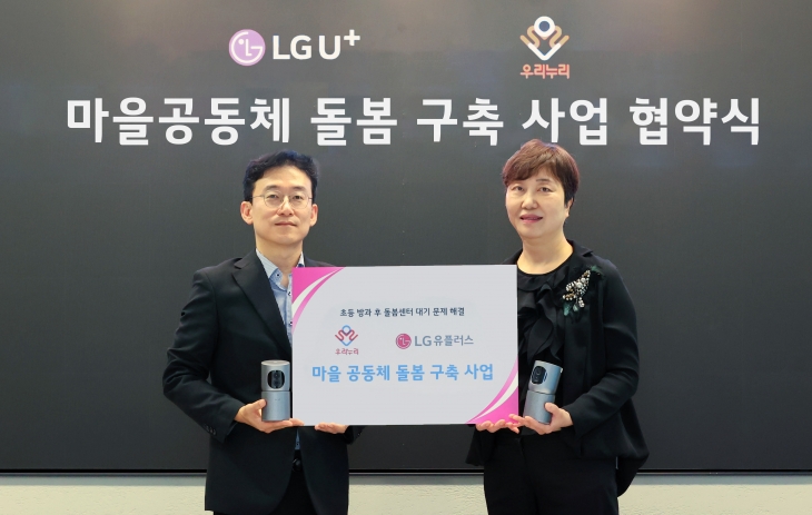 이건영(왼쪽) LG유플러스 스마트홈 사업 담당 상무와 김현아 교육공동체 우리누리 사회적협동조합 이사장이 서울 용산구 LG유플러스 용산 사옥에서 ‘마을공동체 돌봄 구축 사업 협약식’에서 기념 촬영을 하고 있다. LG유플러스 제공