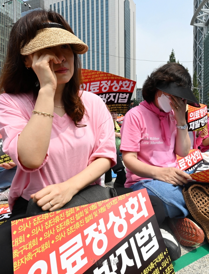 한국환자단체연합회, 한국유방암환우총연합회, 한국희귀·난치성질환연합회 등 환자 단체 회원들이 4일 서울 종로구 보신각 앞에서 의사 집단휴진 철회와 재발방지법 제정을 촉구하는 가운데 참가자들이 코넬리아드랑게 증후군 환자의 어머니인 김정애 씨의 발언을 들으며 눈물을 흘리고 있다. 2024.7.4 홍윤기 기자