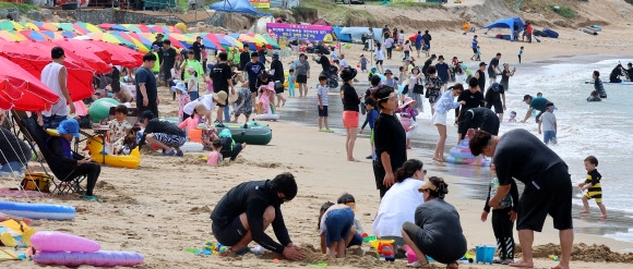 본격적인 휴가철을 맞아 28일 인천 중구 왕산해수욕장을 찾은 피서객들이 더위를 식히고 있다. 연합뉴스