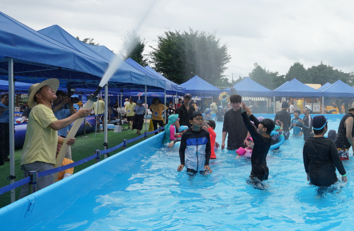 이승로(맨 왼쪽) 서울 성북구청장이 지난 27일 성북동 성북초등학교에서 열린 제8회 성북문화바캉스 개막식에서 풀장 위로 물을 시원하게 뿌리고 있다. 성북구 제공