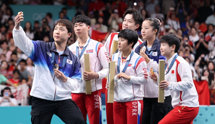 한국 탁구 국가대표 임종훈(왼쪽)이 30일(한국시간) 프랑스 파리 사우스 파리 아레나 4에서 열린 2024 파리올림픽 탁구 혼합복식 시상식에서 같이 시상대에 오른 북한 리정식(왼쪽 두번째)-김금영(가운데 앞) 등과 셀카를 찍고 있다. 파리 연합뉴스