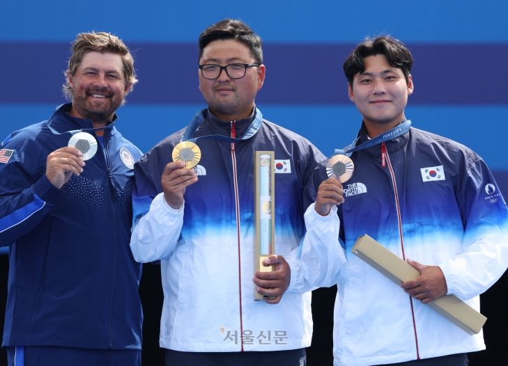 한국 양궁 국가대표 김우진과 이우석이 4일(한국시간) 프랑스 파리 레쟁발리드에서 열린 2024 파리올림픽 남자 개인전 시상식에서 각각 금메달과 동메달을 들어 올리고 있다. 파리 박지환 기자