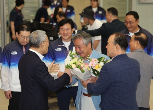 이기흥 대한체육회장이 13일 오후 인천국제공항 제2여객터미널을 통해 귀국해 유인촌 문화체육관광부 장관과 인사를 나누고 있다. 연합뉴스