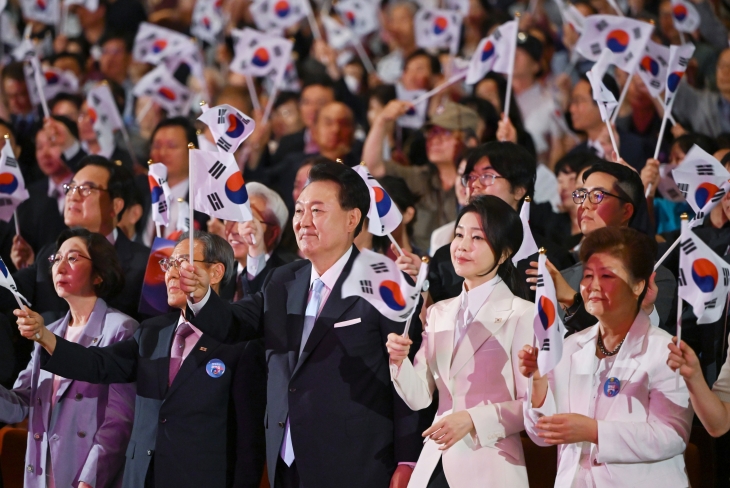 윤석열 대통령과 김건희 여사가 15일 서울 종로구 세종문화회관에서 열린 제79주년 광복절 경축식에서 참석자들과 함께 태극기를 흔들고 있다. 경축식에는 국민의힘 의원 50여명, 독립유공자 유족, 주한외교단, 시민 등 2000여명이 참석했다. 뉴스1