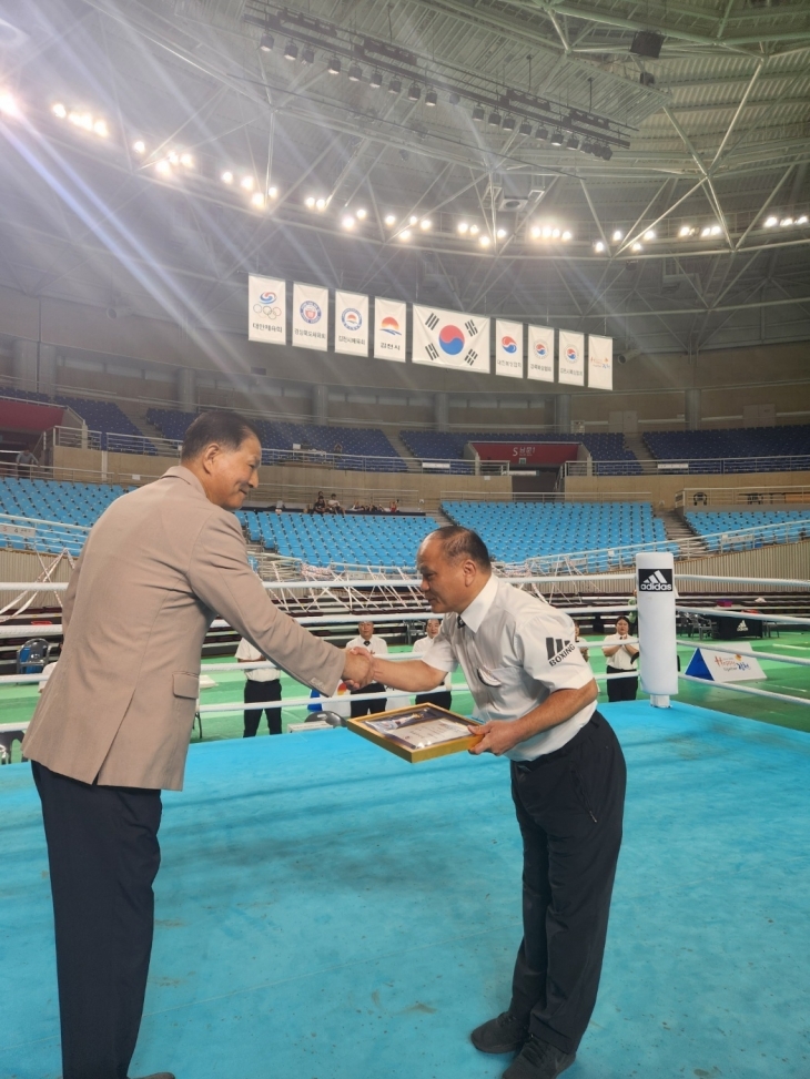 박세림(오른쪽) 순천시청 사회복지과 주무관이 조용준 대한복싱협회 심판장으로부터 우수심판상을 받고 있다.