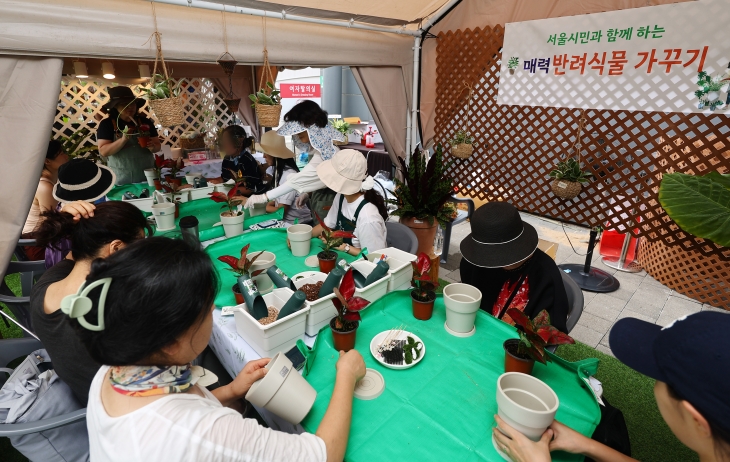 26일 오후 서울 광진구 뚝섬한강공원에서 열린 ‘2024 대한민국정원산업박람회’에서 시민들이 분갈이 체험을 하고 있다. 연합뉴스