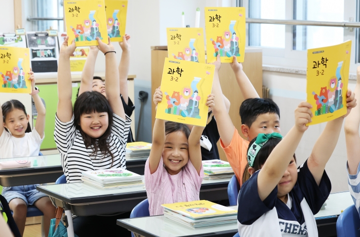 지난달 19일 오전 여름방학을 마치고 개학한 초등학생들이 교과서를 보여주며 환하게 웃고 있다. 2024.8.19 연합뉴스