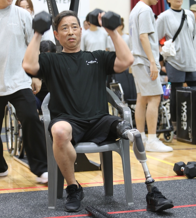 8일 오후 서울 은평구 서부재활체육센터 대체육관에서 열린 ‘어댑핏 게임즈’ 참가자들이 크로스핏 종목을 수행하고 있다. 장애인 아이스하키 국가대표팀 감독으로 이번 대회에 장애인으로 참가한 한민수 감독이 덤벨 들기를 하고 있다. 엔젤스헤이븐 제공