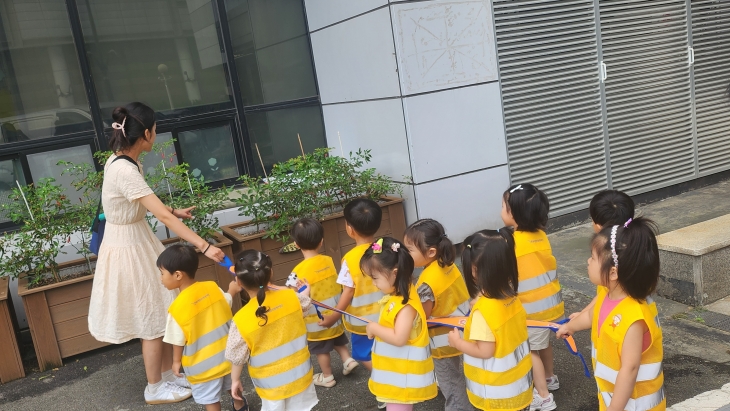 노란 안전조끼를 입은 채 인솔띠를 잡고 있는 서울 송파구의 한 어린이집 아이들. 송파구 제공