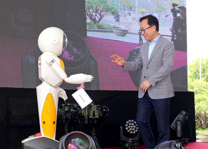 유성훈(오른쪽) 서울 금천구청장이 지난 7일 금천구청 광장에서 열린 금천과학축제에서 사회자로 나선 인간형 로봇 ‘에이미’와 대화하고 있다. 금천구 제공