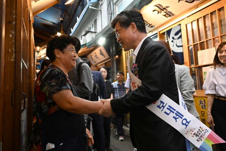 김길성(오른쪽) 서울 중구청장이 지난 11일 인현시장에서 만난 상인과 악수하며 추석맞이 덕담을 주고받고 있다. 중구 제공