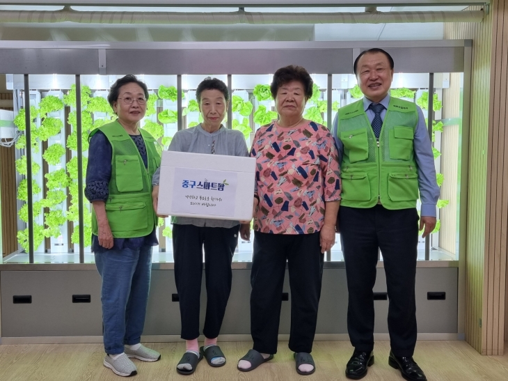 서울 중구에서 조성한 도심형 스마트팜에서 첫 수확물이 나온 가운데 관계자들이 기념 촬영을 하고 있다. 중구 제공