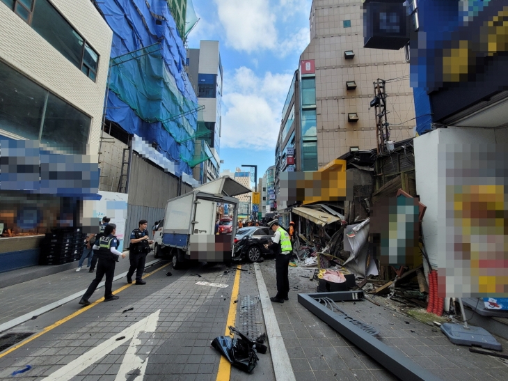 지난 12일 오후 1시쯤 부산 해운대구 해운대어귀삼거리 근처에서 인도로 돌진한 벤츠 차량이 정차 중이던 트럭과 인근 점포를 들이받은 뒤 멈춰 있다. 부산경찰청 제공