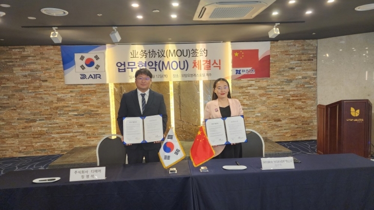 정영석 ㈜디에어 대표와 맹월화 중국 유나이티드 에어크래프트 그룹 부회장이 업무협약 체결 후 기념사진을 찍고 있다.