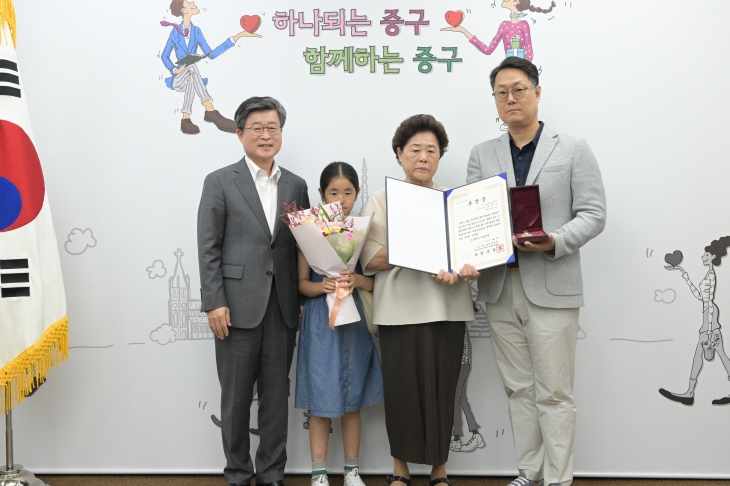 김길성 서울 중구청장(왼쪽)이 6·25 전쟁 당시 나라를 위해 헌신한 고 최현숙씨를 대신해 그의 배우자 강풍자씨와 아들 최승제씨에게 무성화랑 무공훈장을 전달한 후 기념 촬영을 하고 있다. 중구 제공