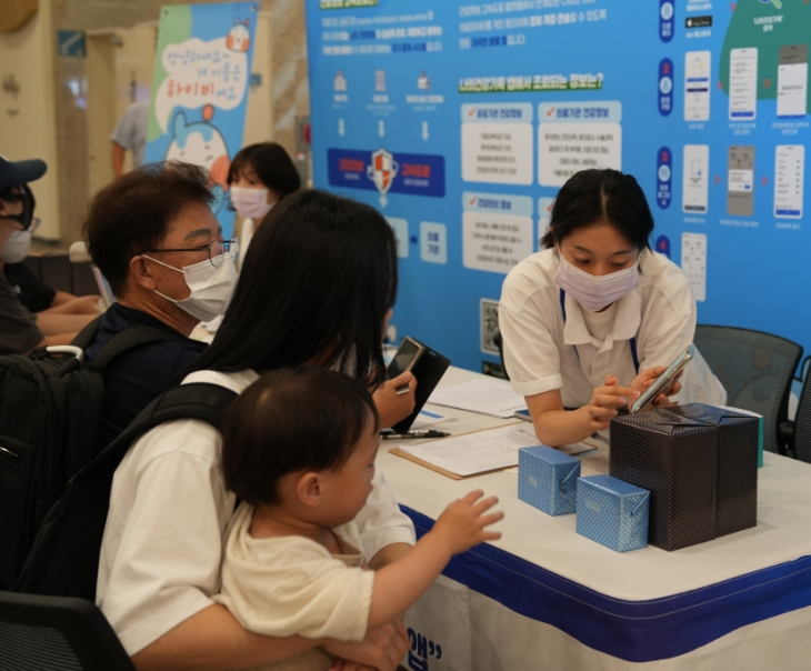 지난 19일 분당서울대학교병원에서 건강정보 고속도로 개통식이 열린 가운데 1층 홍보부스에서 관계자가 환자 및 내방객에게 ‘나의건강기록’ 앱을 통한 건강정보 고속도로 활용 방법을 안내하고 있다. 한국보건의료정보원 제공