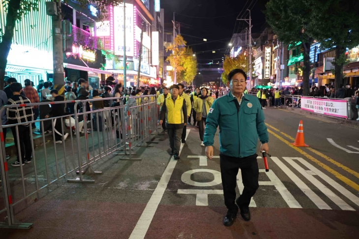 지난해 10월 핼러윈을 맞아 서울 마포구 홍대 레드로드에 많은 인파가 몰리자, 박강수(오른쪽) 마포구청장이 보행로 확보를 위해 설치한 안전펜스를 살피고 있다. 마포구 제공