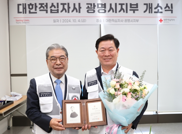 박승원 광명시장(오른쪽)이 이재정 대한적십자사 경기도지사 회장(왼쪽)으로부터 적십자 광명시지부 명예지부회장 위촉패를 전달받고 기념사진을 찍고 있다. 광명시 제공